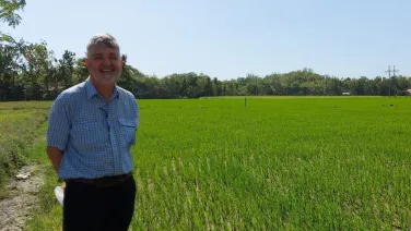 Russell Reinke in a field of Golden Rice in the Philippines in 2023/ANU