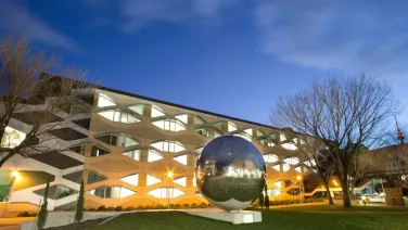Science precinct showing biology building and sculpture of a large metallic ball